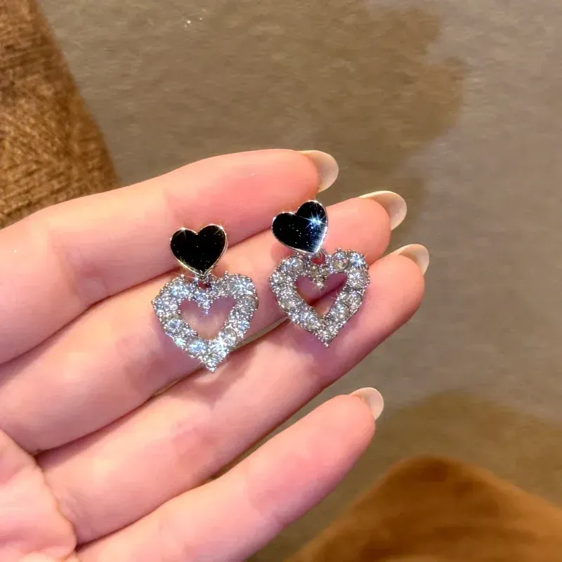 Model showcasing the dangle and style of the 14K Gold-Plated Elegant Bling Bling Heart Earrings