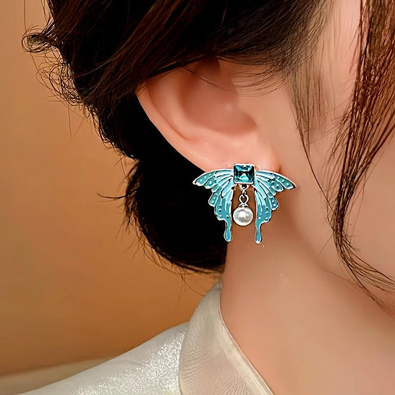 Model showcasing the dangle and style of the 14K Gold-Plated Elegant Blue Butterfly Pearl Earrings