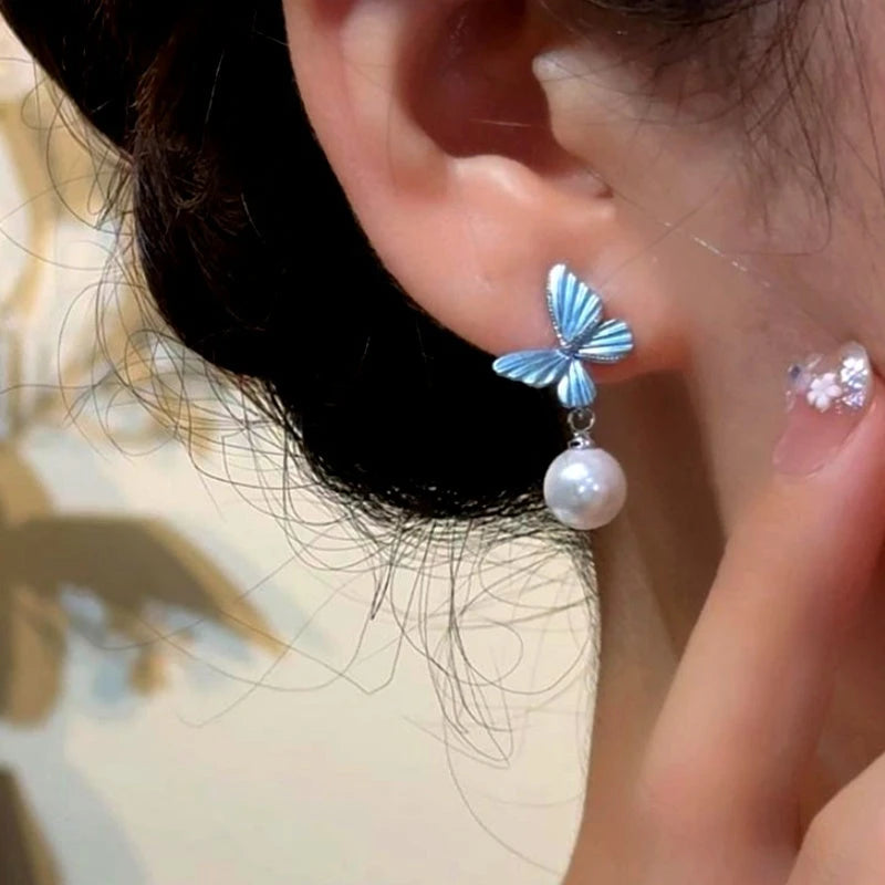 Model showcasing the dangle and style of the 14K Gold-Plated Elegant Blue Butterfly Pearl Earrings