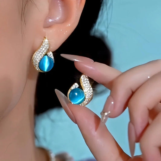 Model showcasing the dangle and style of the 14K Gold-Plated Elegant Blue Cat's Eye Stone Earrings