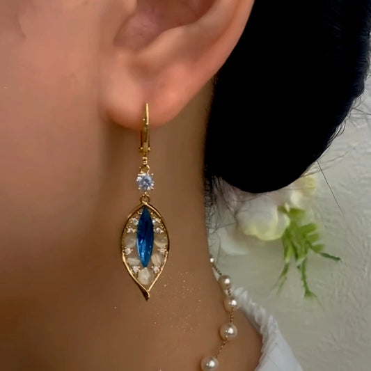 Model showcasing the dangle and style of the 14K Gold-Plated Elegant Blue Diamond Cat's Eye Stone Leaf Earrings