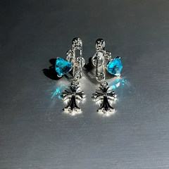 Model showcasing the dangle and style of the 14K Gold-Plated Elegant Blue Diamond Heart Cross Pin Earrings