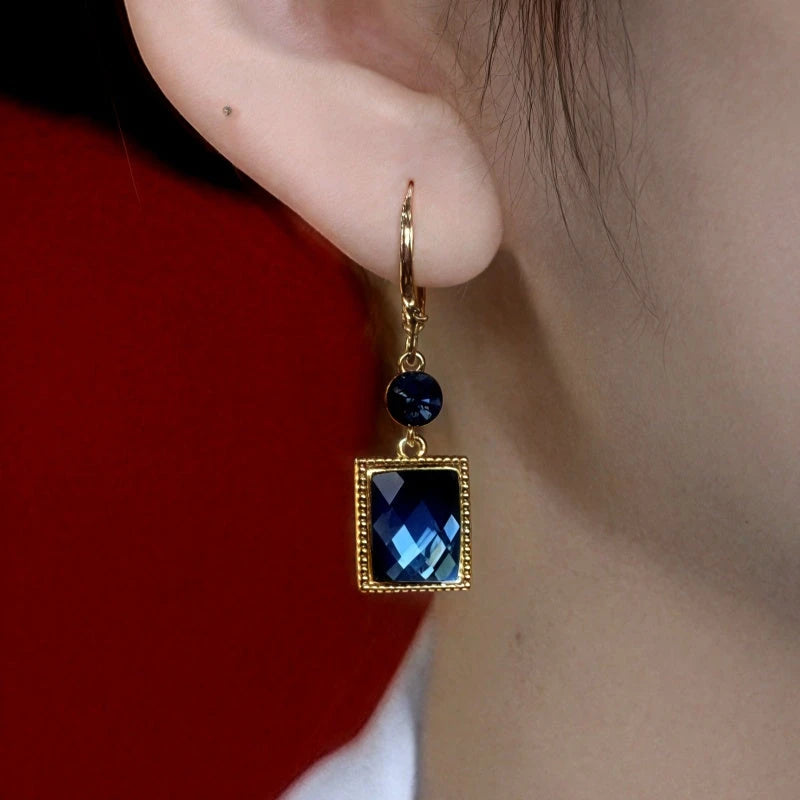 Model showcasing the dangle and style of the 14K Gold-Plated Elegant Blue Square Crystal Earrings