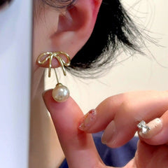 Angled view of the 14K Gold-Plated Elegant Bow Pearl Jacket Earrings