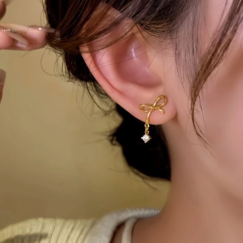 Model showcasing the dangle and style of the 14K Gold-Plated Elegant Bow Zircon Water Drop Earrings
