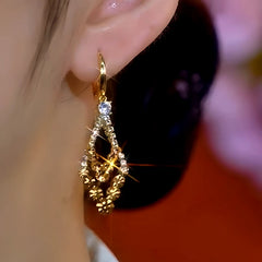 Model showcasing the dangle and style of the 14K Gold-Plated Elegant Brown Diamond Earrings