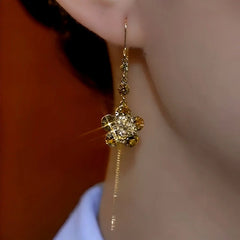 Model showcasing the dangle and style of the 14K Gold-Plated Elegant Brown Diamond Flower Threader Earrings