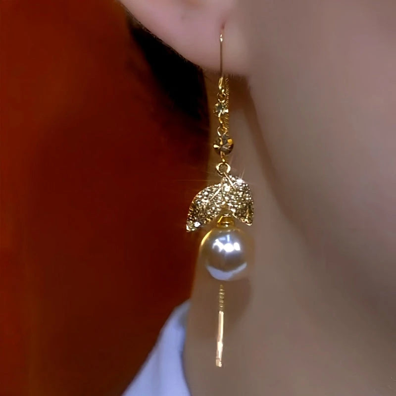 Model showcasing the dangle and style of the 14K Gold-Plated Elegant Brown Diamond Leaf Pearl Threader Earrings