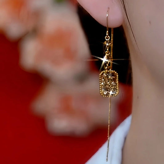 Model showcasing the dangle and style of the 14K Gold-Plated Elegant Brown Diamond Threader Earrings