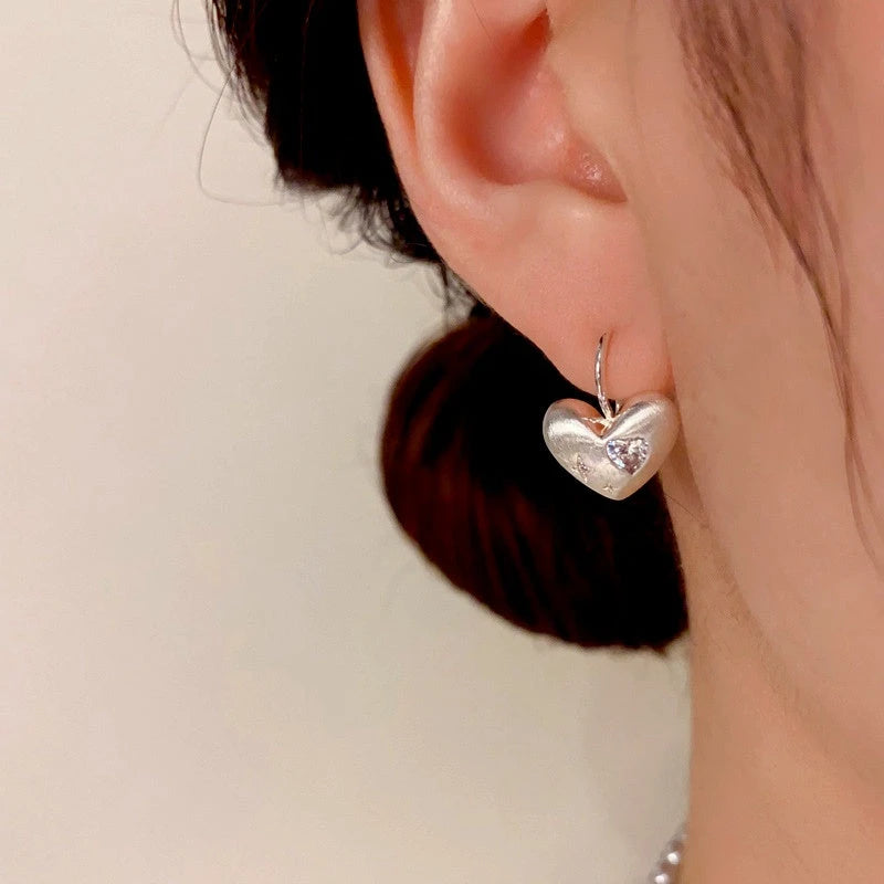 Close-up detail of the sparkling zircons and plating on the Brushed Heart Earrings
