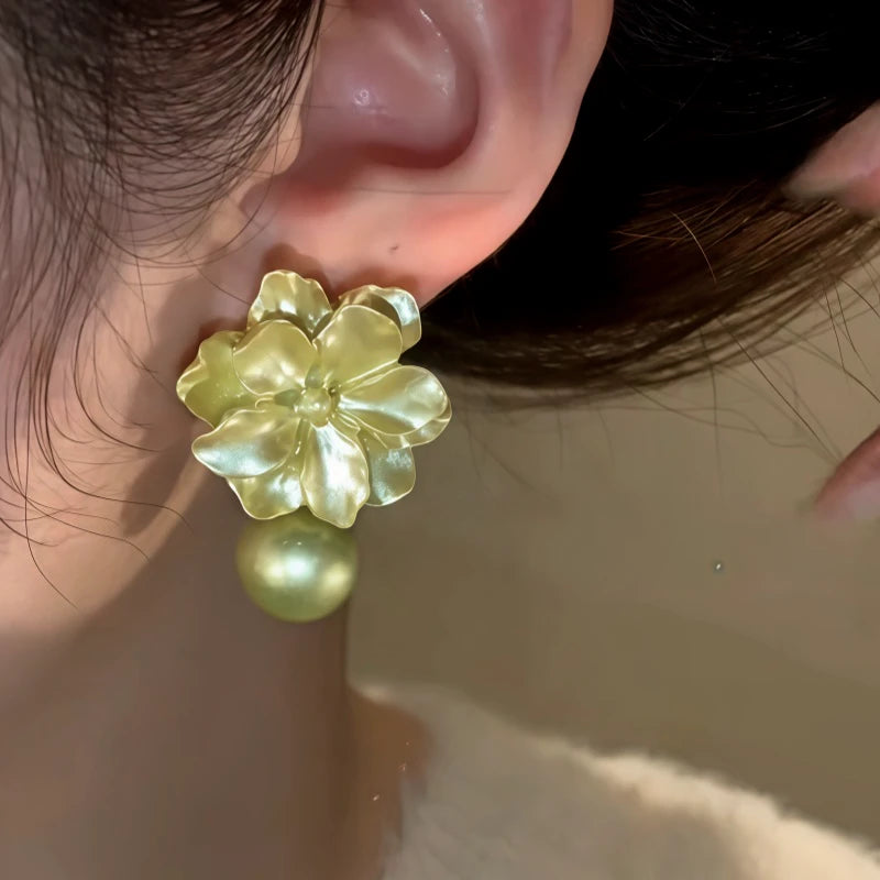 Model showcasing the dangle and style of the 14K Gold-Plated Elegant Camellia Pearl Earrings