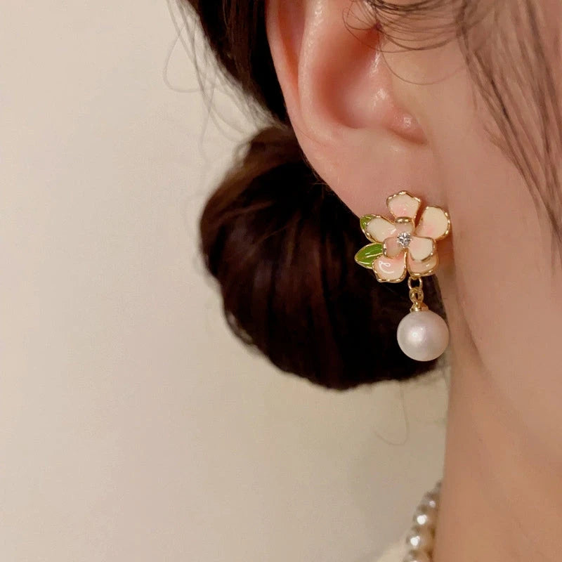 Model showcasing the dangle and style of the 14K Gold-Plated Elegant Camellia Pearl Earrings