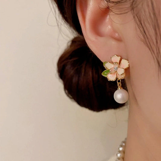 Model showcasing the dangle and style of the 14K Gold-Plated Elegant Camellia Pearl Earrings