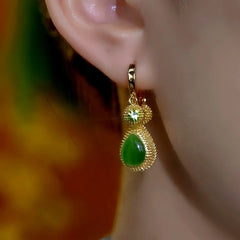 Model showcasing the dangle and style of the 14K Gold-Plated Elegant Cat's Eye Green Durian Earrings