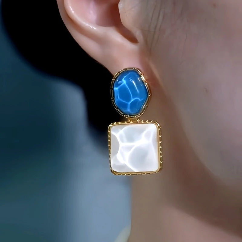 Model showcasing the dangle and style of the 14K Gold-Plated Elegant Cat's Eye Stone Asymmetrical Earrings