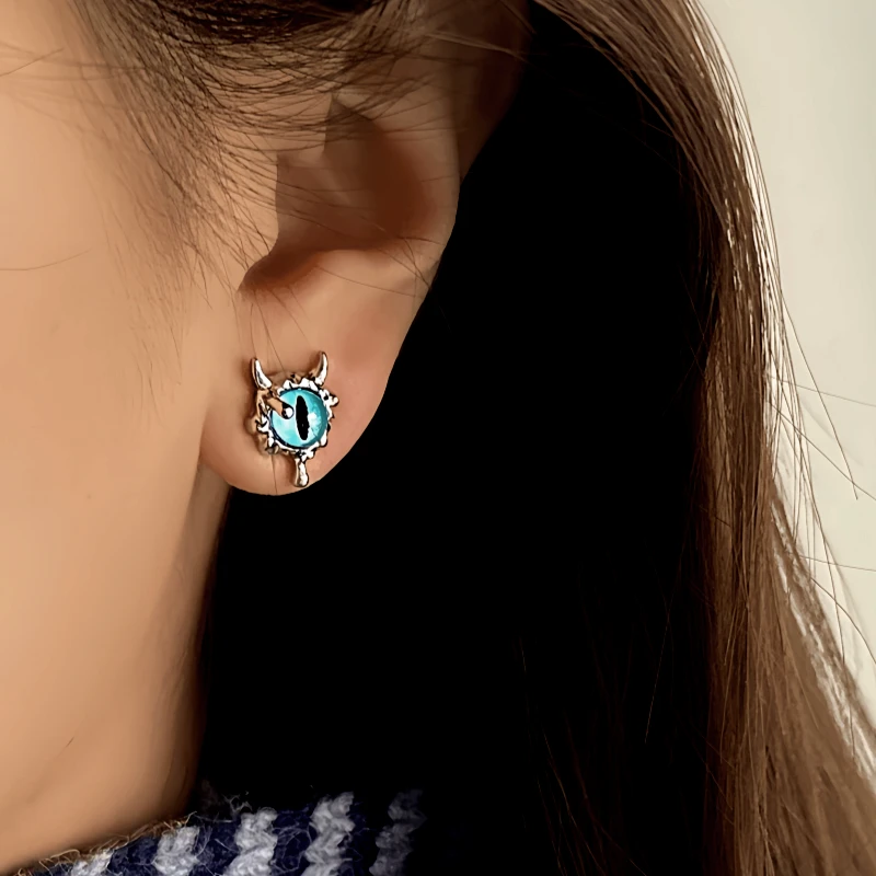 Model showcasing the dangle and style of the 14K Gold-Plated Elegant Cat's Eye Stone Devil Stud Earrings