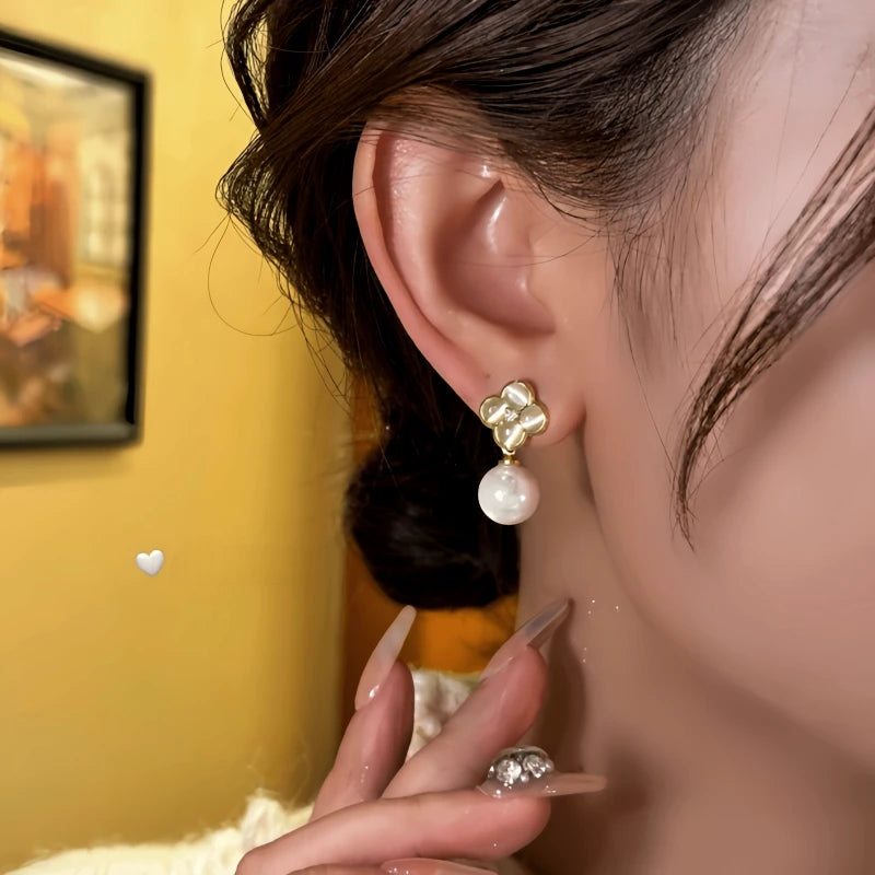 Model showcasing the dangle and style of the 14K Gold-Plated Elegant Cat's Eye Stone Flower Bead Earrings
