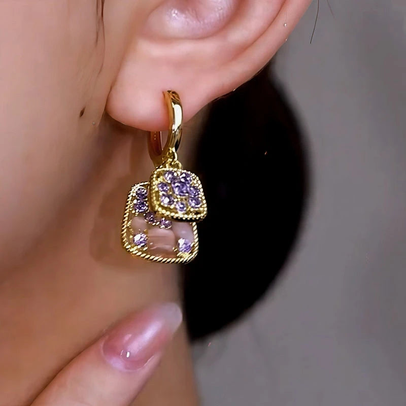 Model showcasing the dangle and style of the 14K Gold-Plated Elegant Cat's Eye Stone Purple Diamond Earrings