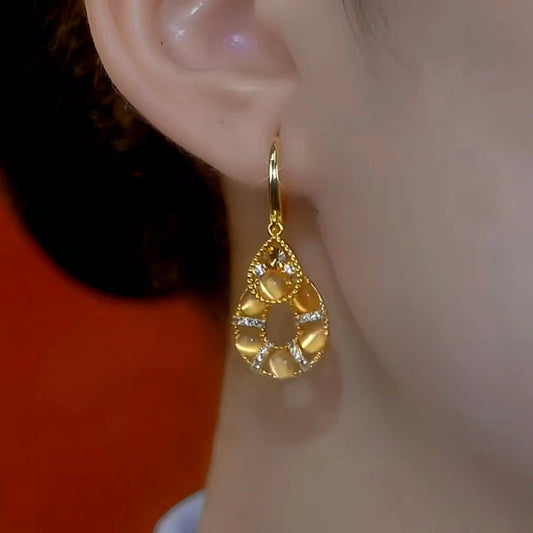 Model showcasing the dangle and style of the 14K Gold-Plated Elegant Cat's Eye Stone Water Drop Earrings