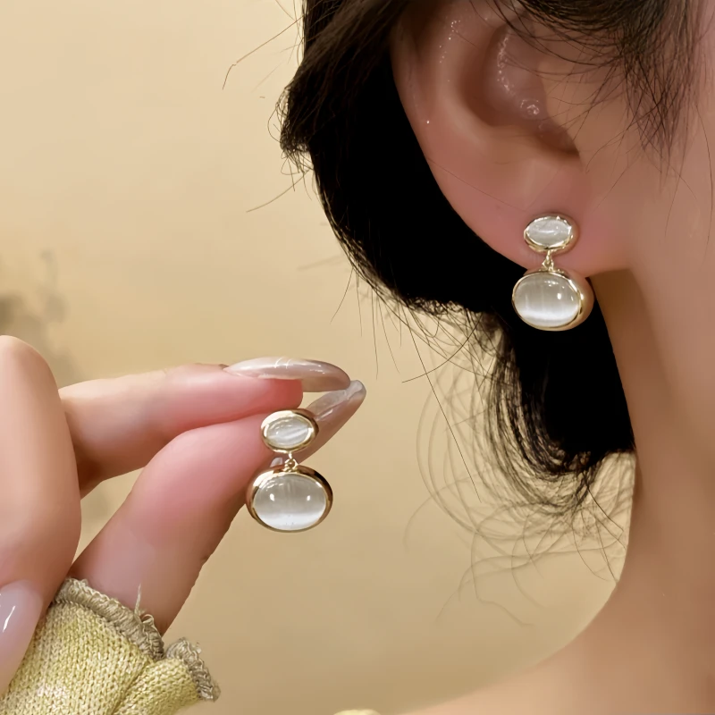 Model showcasing the dangle and style of the 14K Gold-Plated Elegant Cat's Eye Stone Water Drop Earrings