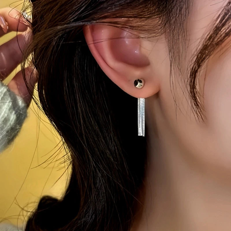 Model showcasing the dangle and style of the 14K Gold-Plated Elegant Chain Tassel Earrings