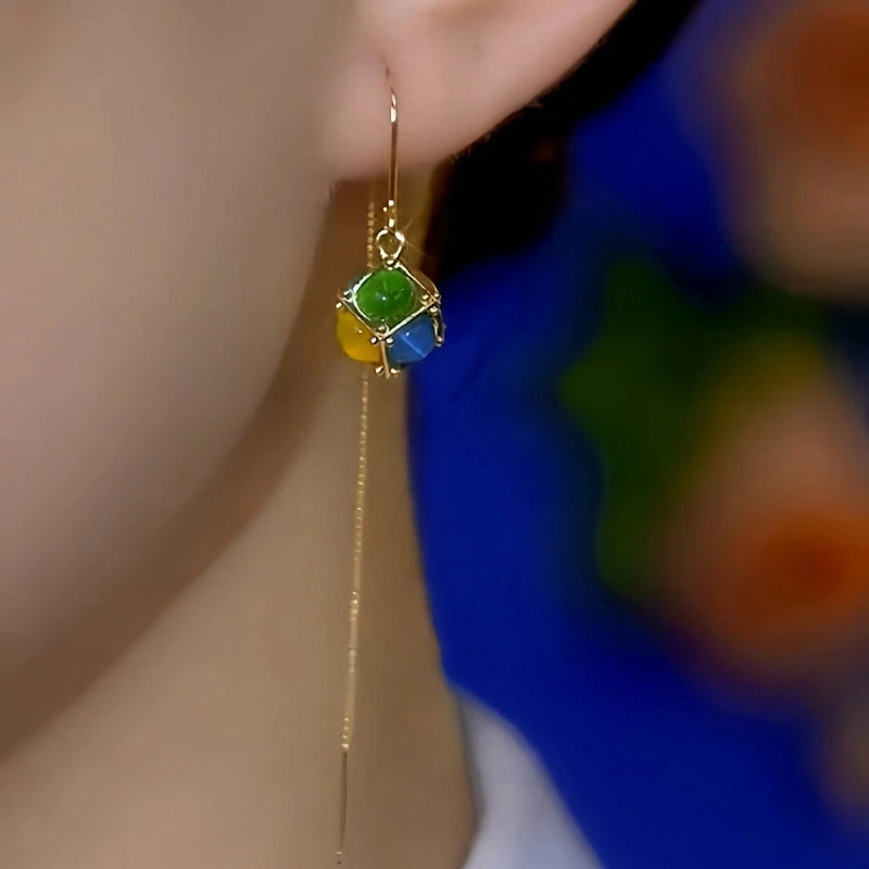 Model showcasing the dangle and style of the 14K Gold-Plated Elegant Colorful Cat's Eye Stone Ball Threader Earrings