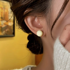 Model showcasing the dangle and style of the 14K Gold-Plated Elegant Cream White Bead Stud Earrings