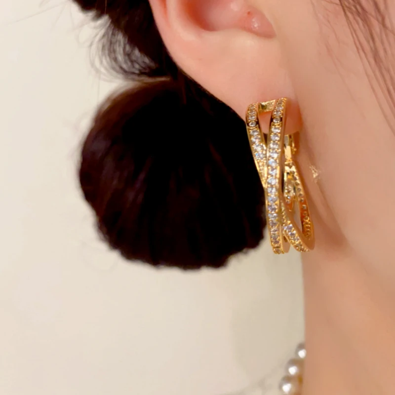 Close-up detail of the sparkling zircons and plating on the Cross Hoop Earrings