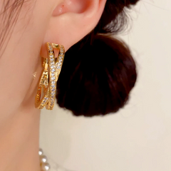 Model showcasing the dangle and style of the 14K Gold-Plated Elegant Cross Daimond Hoop Earrings