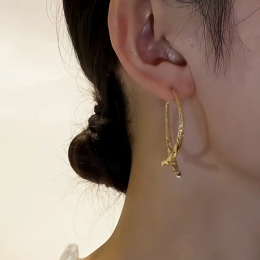 Model showcasing the dangle and style of the 14K Gold-Plated Elegant Cross Earrings