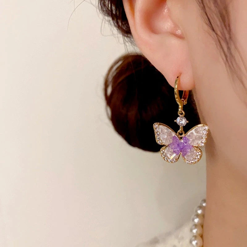 Model showcasing the dangle and style of the 14K Gold-Plated Elegant Crystal Butterfly Earrings