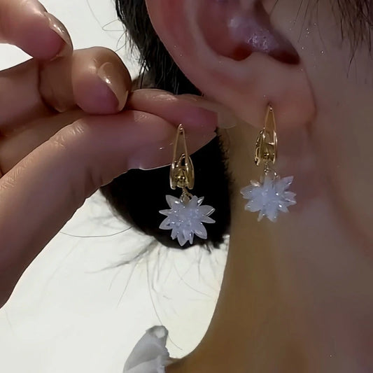 Model showcasing the dangle and style of the 14K Gold-Plated Elegant Crystal Snowflake Earrings