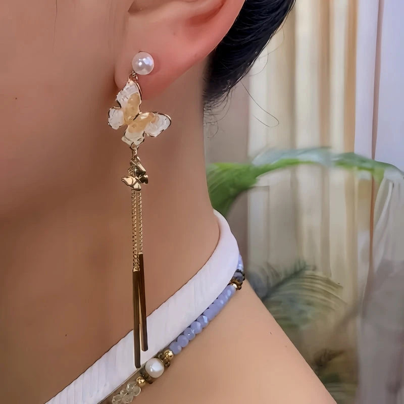 Model showcasing the dangle and style of the 14K Gold-Plated Elegant Crytsal Butterfly Tassel Earrings