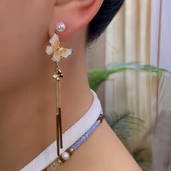 Model showcasing the dangle and style of the 14K Gold-Plated Elegant Crytsal Butterfly Tassel Earrings
