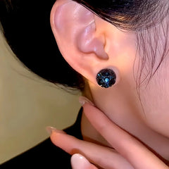 Angled view of the 14K Gold-Plated Elegant Dark Blue Rhinestone Round Magnetic Earrings