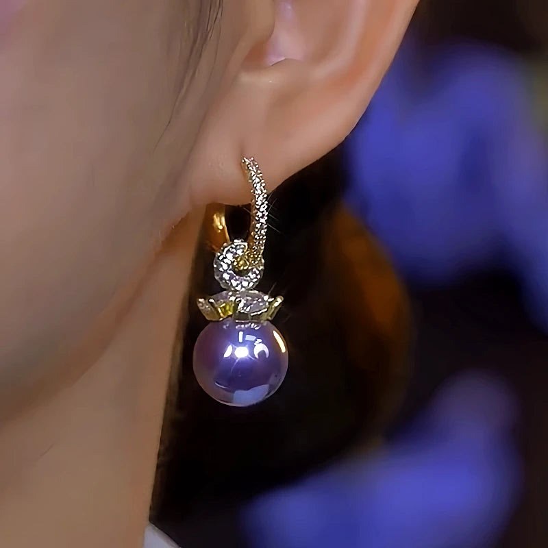 Model showcasing the dangle and style of the 14K Gold-Plated Elegant Diamond-Studded Purple Pearl Earrings