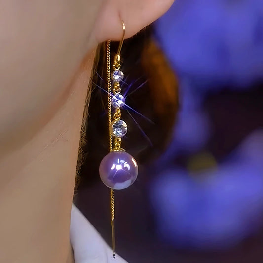 Model showcasing the dangle and style of the 14K Gold-Plated Elegant Diamond-Studded Purple Pearl Threader Earrings