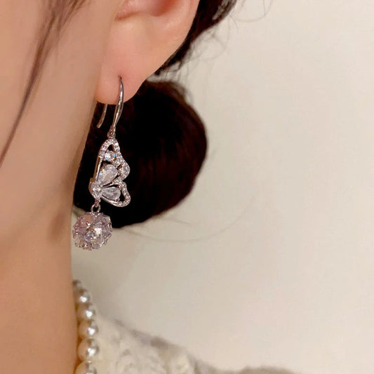 Model showcasing the dangle and style of the 14K Gold-Plated Elegant Diamond Butterfly Ball Ear Hooks