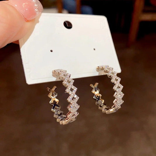 Model showcasing the dangle and style of the 14K Gold-Plated Elegant Diamond C-Shaped Earrings