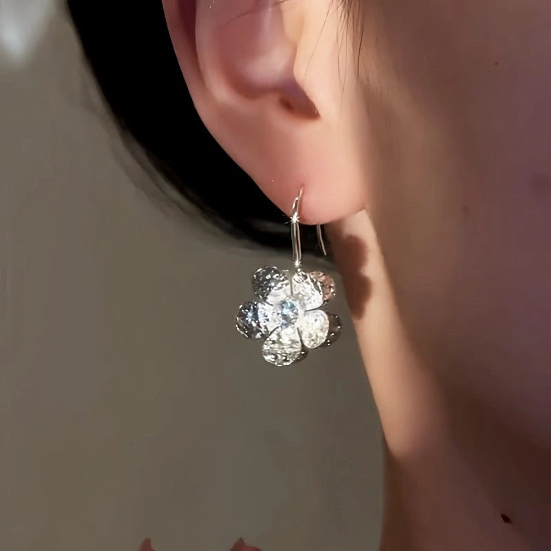 Model showcasing the dangle and style of the 14K Gold-Plated Elegant Diamond Flower Ear Hooks