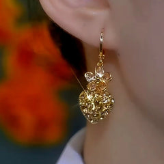 Model showcasing the dangle and style of the 14K Gold-Plated Elegant Diamond Flower Heart Earrings