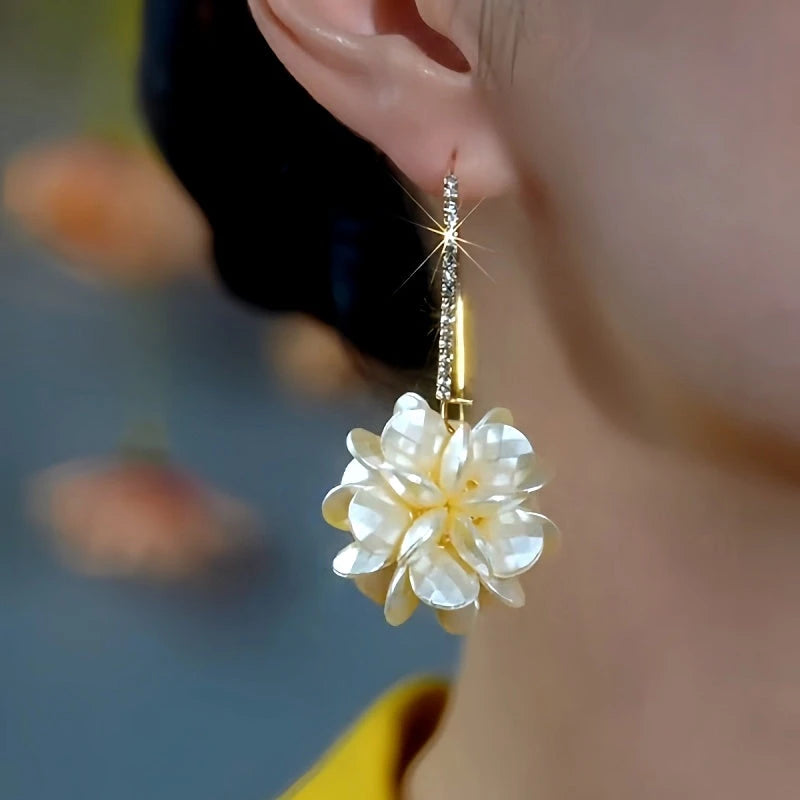 Model showcasing the dangle and style of the 14K Gold-Plated Elegant Diamond Flower Pearl Earrings