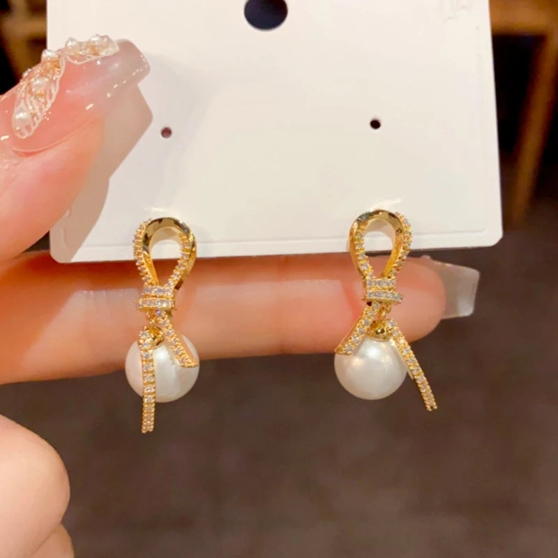 Close-up detail of the sparkling zircons and plating on the Knotted Pearl Earrings