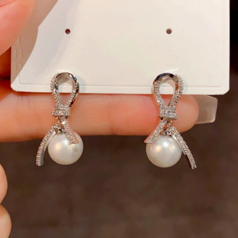 Angled view of the 14K Gold-Plated Elegant Diamond Knotted Pearl Earrings