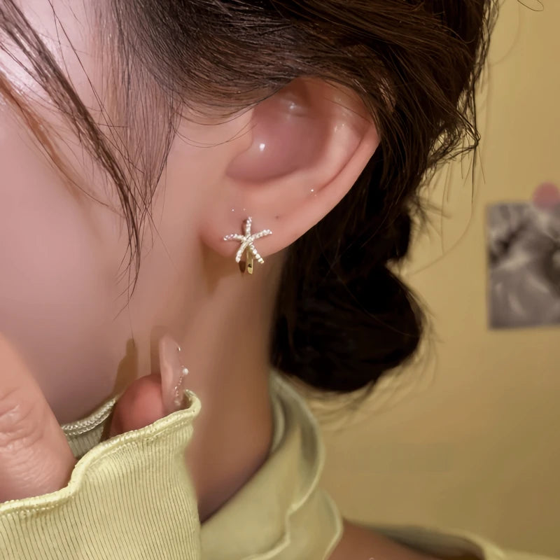 Model showcasing the dangle and style of the 14K Gold-Plated Elegant Diamond Starfish Hoop Earrings