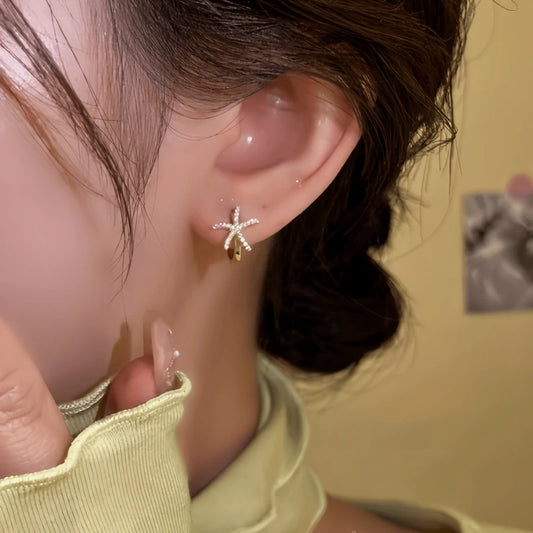 Model showcasing the dangle and style of the 14K Gold-Plated Elegant Diamond Starfish Hoop Earrings