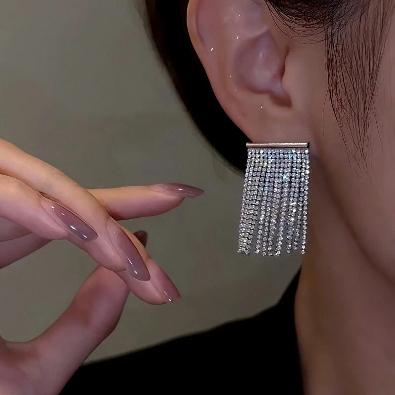 Model showcasing the dangle and style of the 14K Gold-Plated Elegant Diamond Tassel Earrings