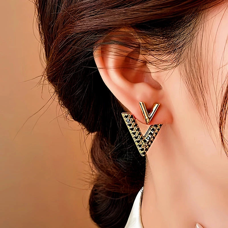 Model showcasing the dangle and style of the 14K Gold-Plated Elegant Diamond V Letter Earrings