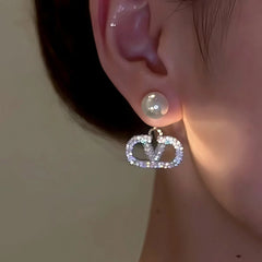 Model showcasing the dangle and style of the 14K Gold-Plated Elegant Diamond V Letter Pearl Earrings