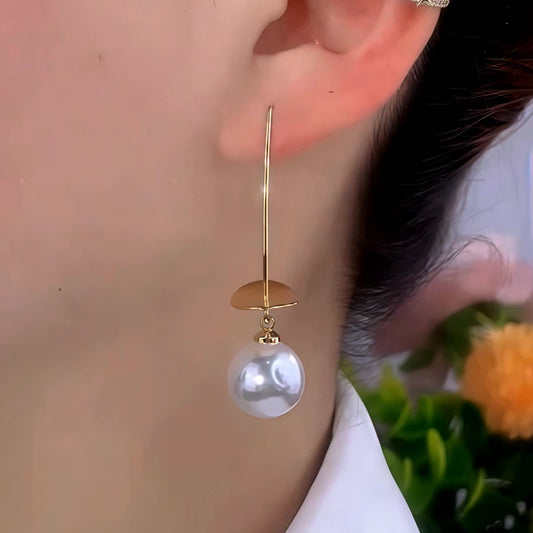 Model showcasing the dangle and style of the 14K Gold-Plated Elegant Disc Pearl Long Ear Hooks
